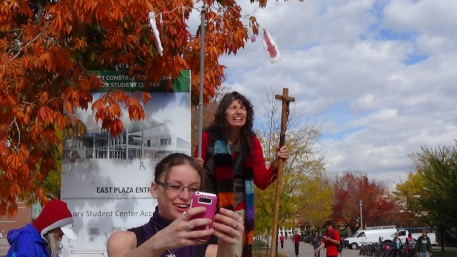 A student takes a selfie in front of the woman and her bloody props on the CSU plaza. (Photo credit: Haleigh McGill)