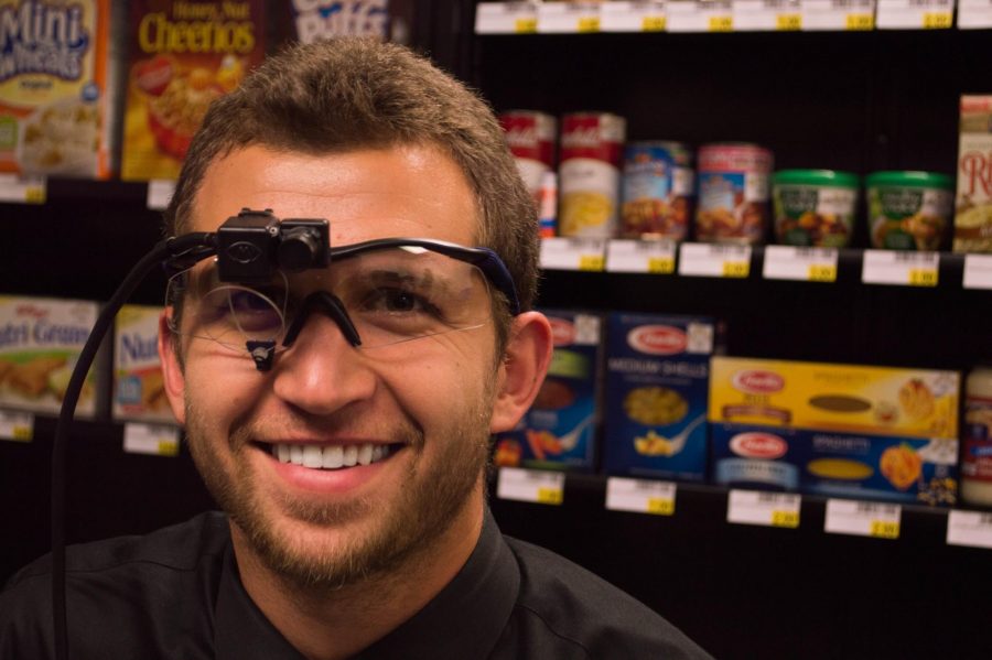 Charlie Heidrick wears the eye scanning glasses used in Dan Grahams grochery shopping simulation lab.