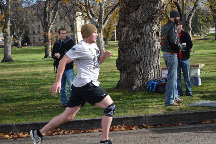 Jason Sydoriak, a political science senior, crosses the finish line of his first 5K race since he was injured in active military duty. Sydoriak was injured in a blast, leaving his left heel bone shattered while serving in the United States Marine Corps. (Photo Credit: Megan Fischer)
