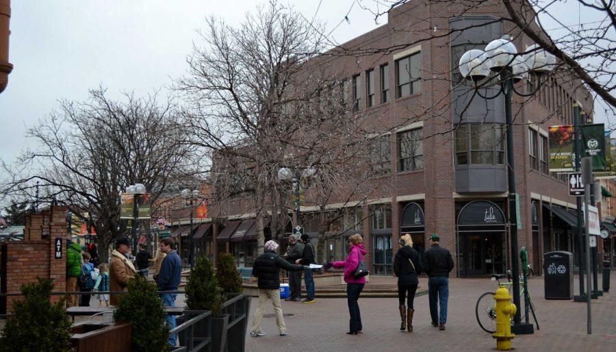 Fort Collins residents stroll around Old Town Square regardless of chilly temperatures and light snow.
