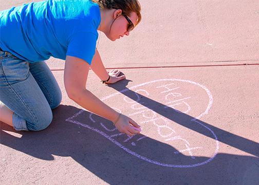 ESA Club President Anne-Marie Kottenstette chalks up the LSC plaza on Sunday in support of the clubs Valentines Day rose fundraiser. (Photo credit: Cameron Bumsted)