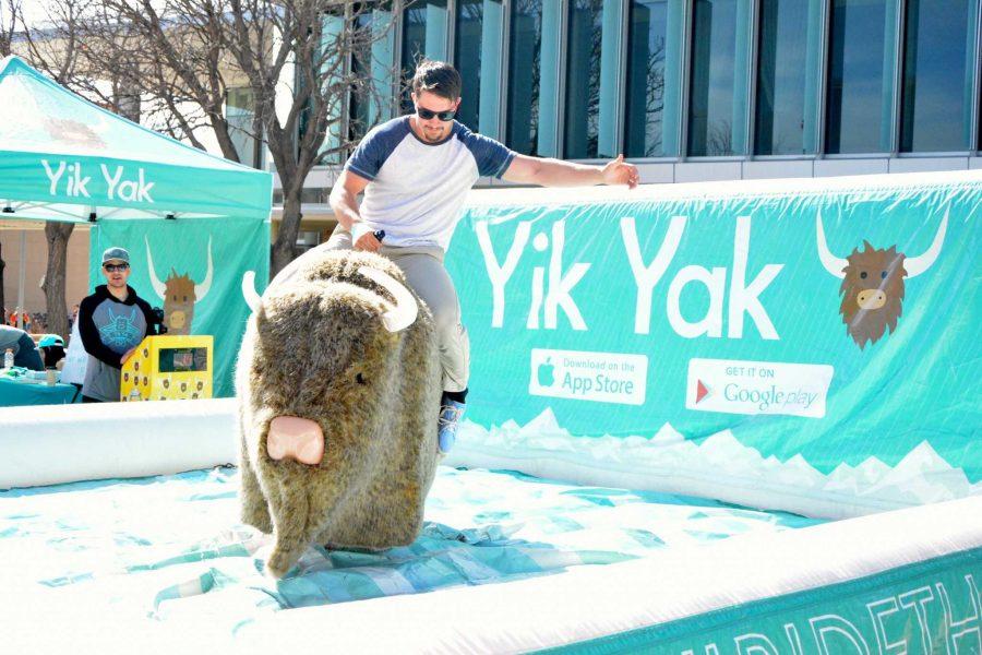 George Wozniak, sophomore health and exercise science major, rides a mechanical yak in an attempt to win yak-themed prizes.
(Photo credit: Ellie Mulder)