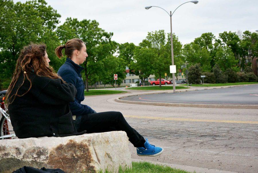 Stadium protestors Claire Peterson and Kacey Flemming sit on top of the last boulder to be removed from the parameter of Meridian Avenue in an effort to halt stadium construction.