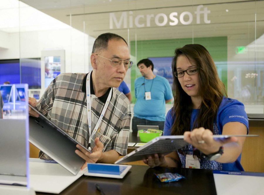 Microsoft Product Advisor Stephanie Le, right, answers questions about a laptop for Windows 10 Insider Eddie Tan of Fremont, Calif., at the Microsoft store at Westfield Valley Fair mall in Santa Clara, Calif., on Wednesday, July 29, 2015. (LiPo Ching/Bay Area News Group/TNS)