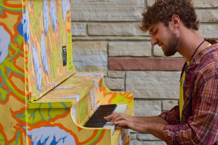 Chemical and biological engineering Junior, Eric Ferguson, plays the piano outside the Lory Student Center. This piano, like others in Fort Collins, was painted by an artist and sits outside for people to play and for others to enjoy. (Photo Credit: Megan Fischer)