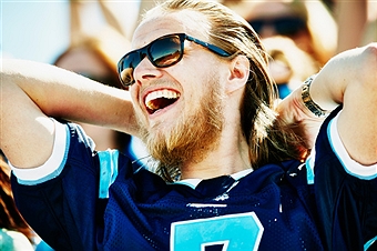 Laughing football fan celebrating after football game in stadium