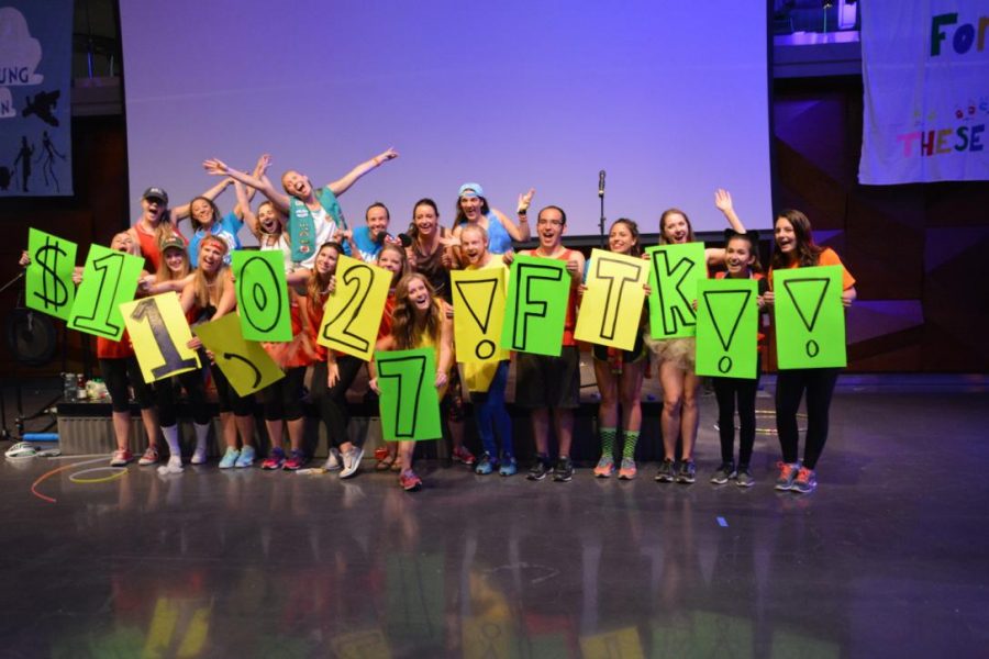 Students who helped organized the Dance Marathon exitedly and proudly hold up signs for the amount they raised for Children's Hospital Saturday. (Photo Credit: Megan Fischer)