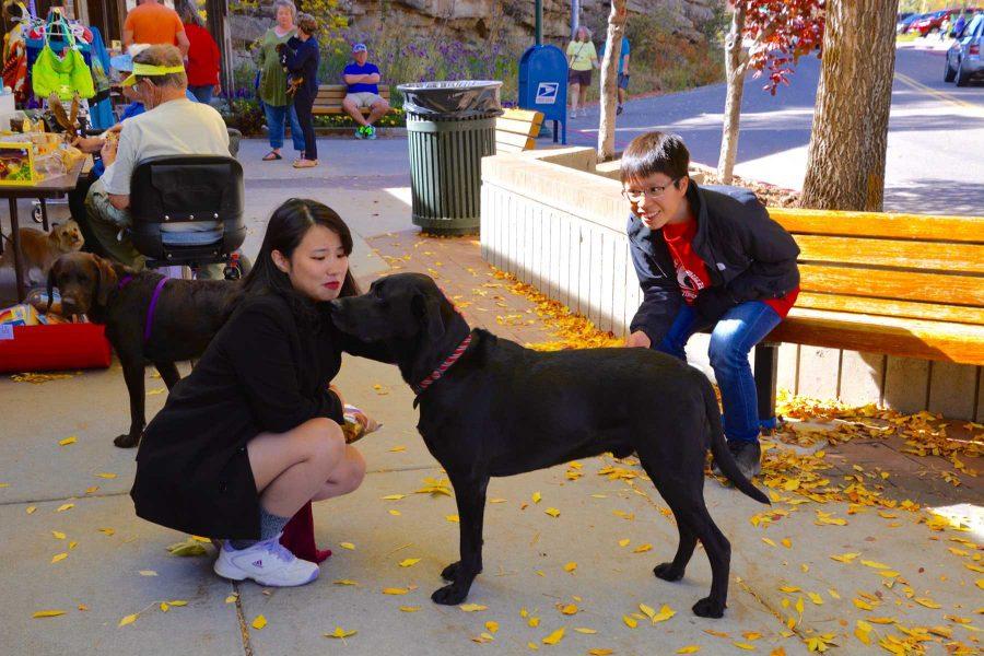 Economics students Vân Hoàng and Xuan Le pet dogs in Estes Park over the weekend. They took a trip to Rocky Mountain National Park to see the changing colors of the leaves for fall. (Photo Credit: Megan Fischer)