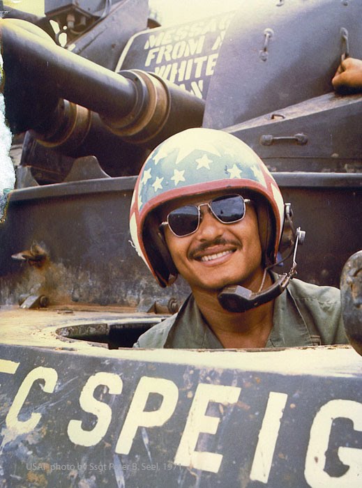 An army tank driver near the Cambodian border. Note the message above the gun and the helicopter reflected in his sunglasses. (Photo courtesy of Pete Seel).