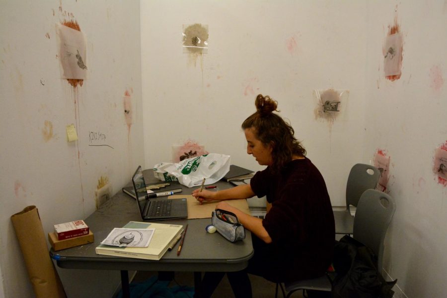 Art student Holly Nordeck works on her roadkill inspired drawings during the 17-hour art marathon Friday night.