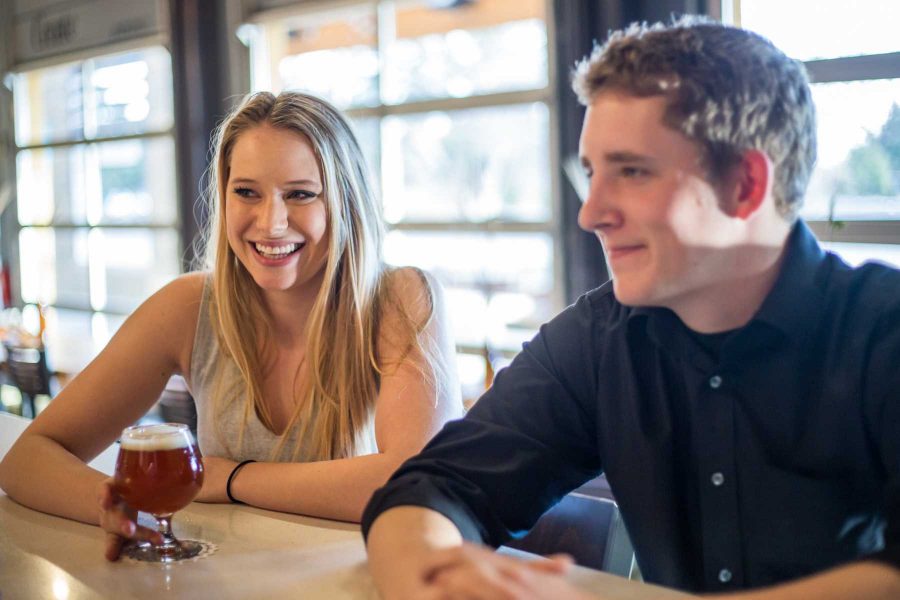 Senior Emery Love, a journalism major interning at the Fort Collins Brewery, jokes with a bar tender and enjoys a beer at the restaurant in FCB Friday. Photo by Ryan Arb