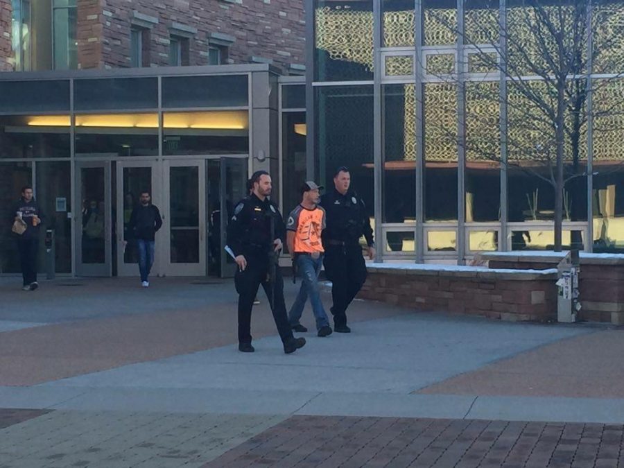 A man who entered Morgan Library with a machete is escorted out of the building by police Monday. Photo by Cassandra Ozee.