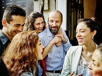 Smiling multi-generational family talking and laughing during party