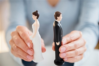 Hands holding bride and groom cake toppers