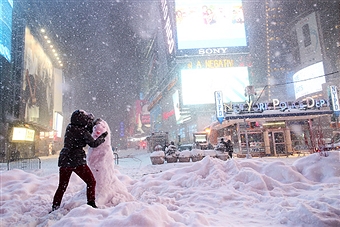 NEW YORK - JANUARY 23: A woman helps decorate a snowman built in Times Square on January 23, 2016 in New York, after a huge snow storm slammed into the Mid-Atlantic States. (Photo by Yana Paskova)