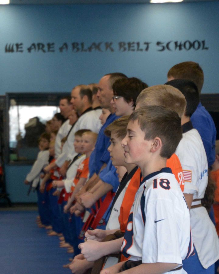 A group of students at a local martial arts school sport their Broncos pride during their on Saturday. Students were allowed to wear broncos shirts and jerseys during class instead of thier regular uniform tops if they wanted in order to show their support for the Sunday Superbowl game. (Photo Credit: Megan Fischer)