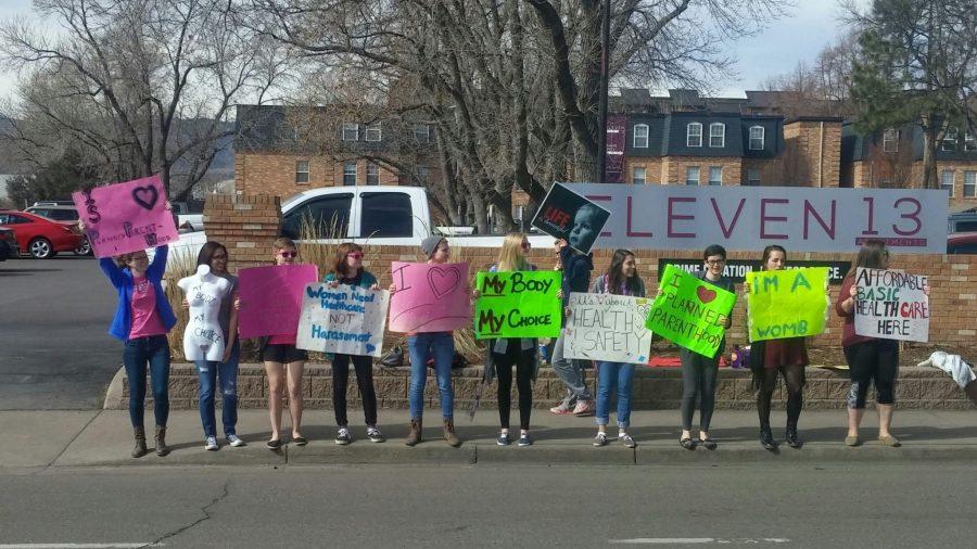 The CSU student organization Students United for Reproductive Justice gathers near Planned Parenthood Clinic to support the Pro-Choice movement. One member from the CSU student organization Students for Life walks by in the background heading toward the Pro-Life group standing nearby. Photo credit of Rachael Martel.