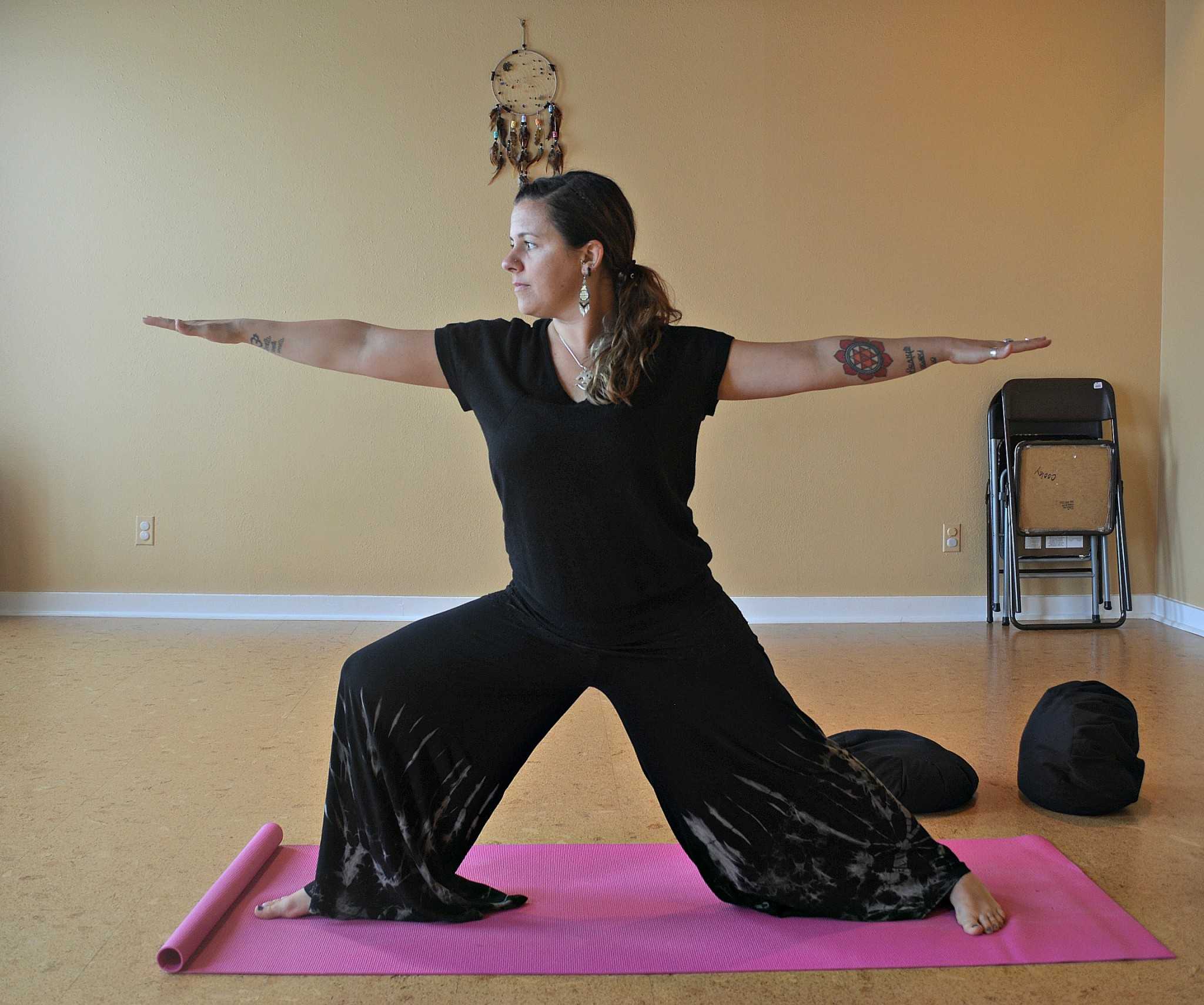 Whitney Barry posing in Vinyasa yoga position called Virabhadrasana. 