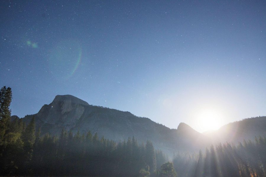 (Full Moon at the end of the Summer Solstice in Yosemite National Park. The headlamps of climbers can be seen on Half Dome. Photo by: Nevin Fowler)
