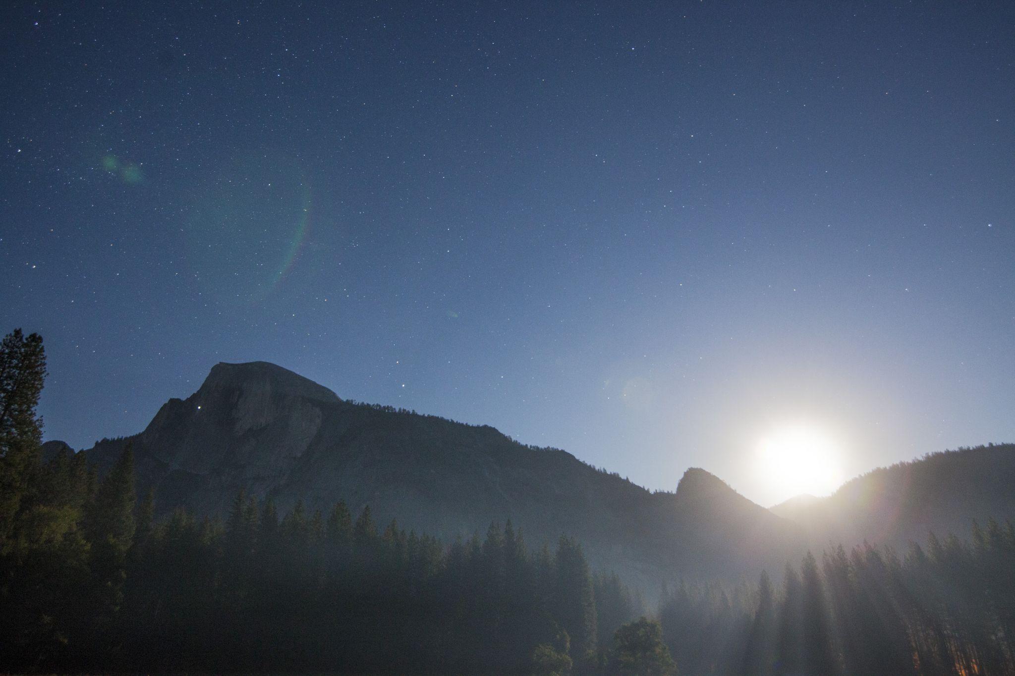 Full moon at the end of the summer solstice in Yosemite National Park. The headlamps of climbers can be seen on Half Dome. Courtesy of Nevin Fowler)