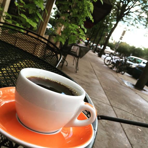 A cup of coffee sits on a table outside the Bean Cycle coffee shop. The Bean Cycle is one of 17  local shops participating in the Caffeine Crawl (Photo Courtesy of The LAB)