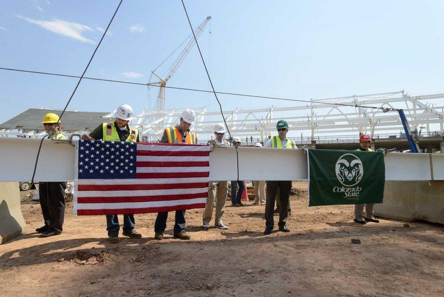 Donors and works sign the final beam before it is moved into place in the new on campus stadium (Luke Walker/ Collegian)