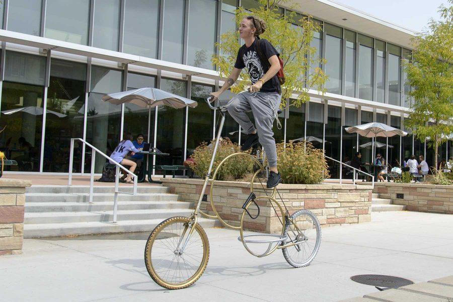 Dylan Johnson demonstrates how he gets up to the seat on his custom made bicycle outside the Lory Student Center on August 31st, 2016. Photo credit: Luke Walker
