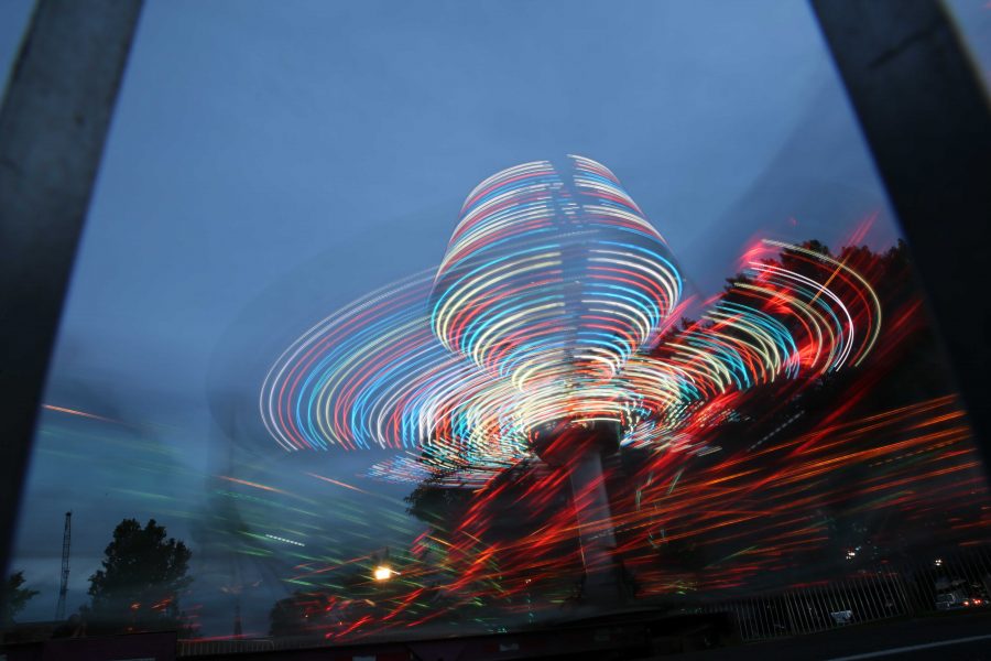A spinning carnival ride glows while being ridden as the sun sets on the first night of Ram Welcome activities on Thursday, August 18th. The Ram Welcome weekend featured carnival rides, games, music, and many other activities for incoming CSU freshman to participate in during their first week at Colorado State University. (Forrest Czarnecki/Collegian)