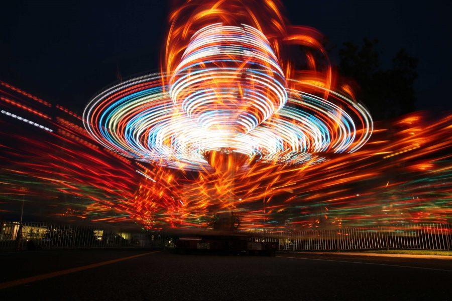 A spinning carnival ride glows while being ridden as the sun sets on the first night of Ram Welcome activities on Thursday, August 18th. The Ram Welcome weekend featured carnival rides, games, music, and many other activities for incoming CSU freshman to participate in during their first week at Colorado State University. (Forrest Czarnecki/Collegian)