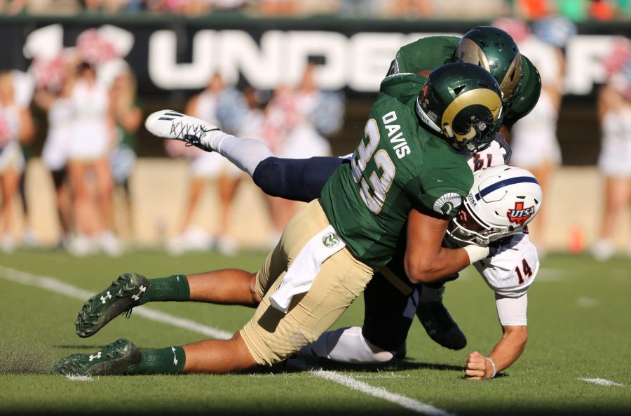 Colorado State Universitys Kevin Davis (33) and Josh Watson (55) tackle University of Texas San Antonios Dalton Sturm (14) during the game against the University of Texas San Antonio on Saturday afternoon at Hughes Stadium. CSU beat the Roadrunners 23-14.