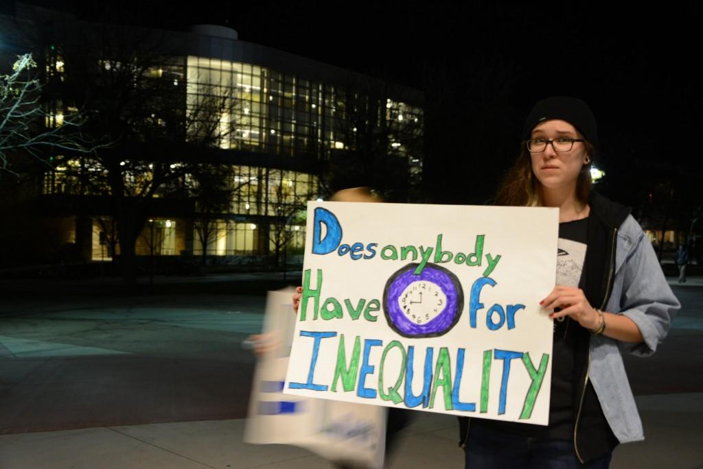 a person holding a sign that reads "Does anyone have time of inequality"