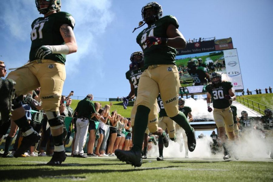 The Colorado State University football team storms the field before the start of the game against UTSA on Saturday afternoon at Hughes Stadium.