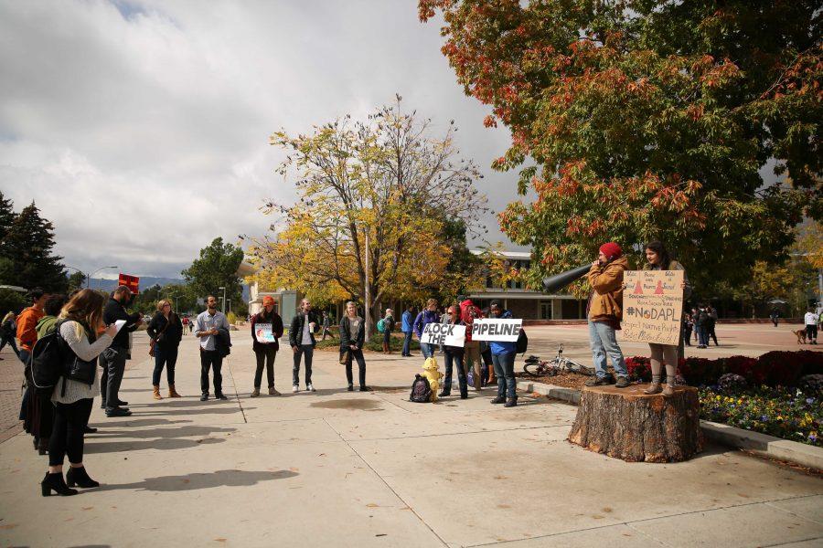 Colorado State University students Griselda Landa-Posas, right, and Adam Lovell, with megaphone, shout and protest the Dakota Access Pipeline on Thursday afternoon in the plaza. Students gathered in the plaza on Thursday afternoon to protest the controversial pipeline.  (Forrest Czarnecki | Collegian)