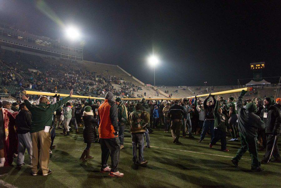 Fans rush the field and carry around a goal post at the end of the game against New Mexico at Hughes Stadium on Nov 19. This is the final game that will be played at Hughes Stadium before the opening of an on campus stadium in 2017. (Luke Walker | Collegian)