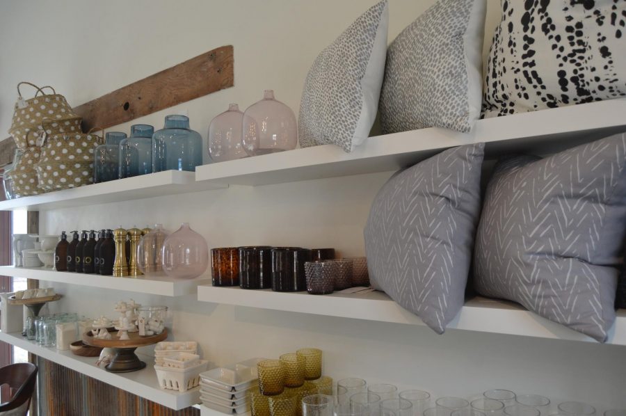 A shelf in Knapsack displays modern throw pillows and kitchen accessories. Photo credit: Nicole Towne