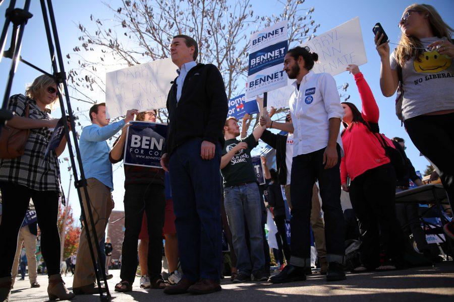 Supporters of Democratic U.S. Senator Michael Bennet and his Republican opponent Darryl Glenn jockey for position behind Bennet while he does an on-air TV interview in the Plaza on Thursday, November 3rd. (Forrest Czarnecki | Collegian)