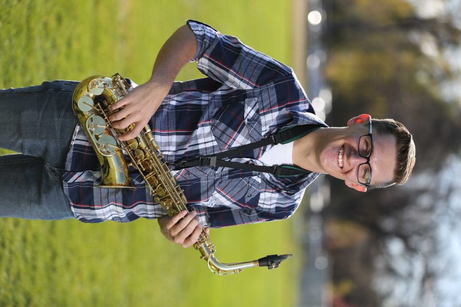 Colorado State University's Trenten Robinson poses for a portrait with his saxophone at the field where the marching band practices. (Forrest Czarnecki | Collegian)