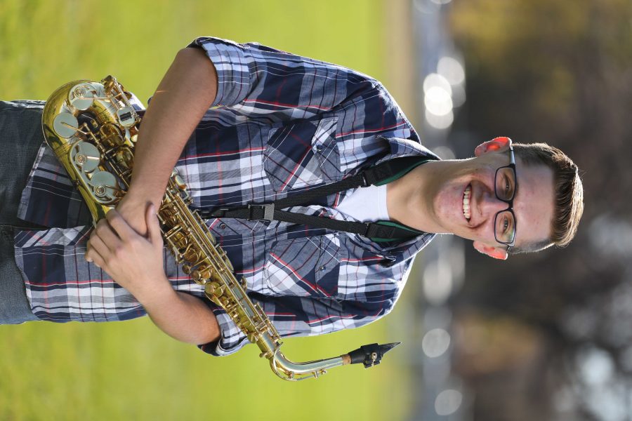 Colorado State University's Trenten Robinson poses for a portrait with his saxophone at the field where the marching band practices. (Forrest Czarnecki | Collegian)