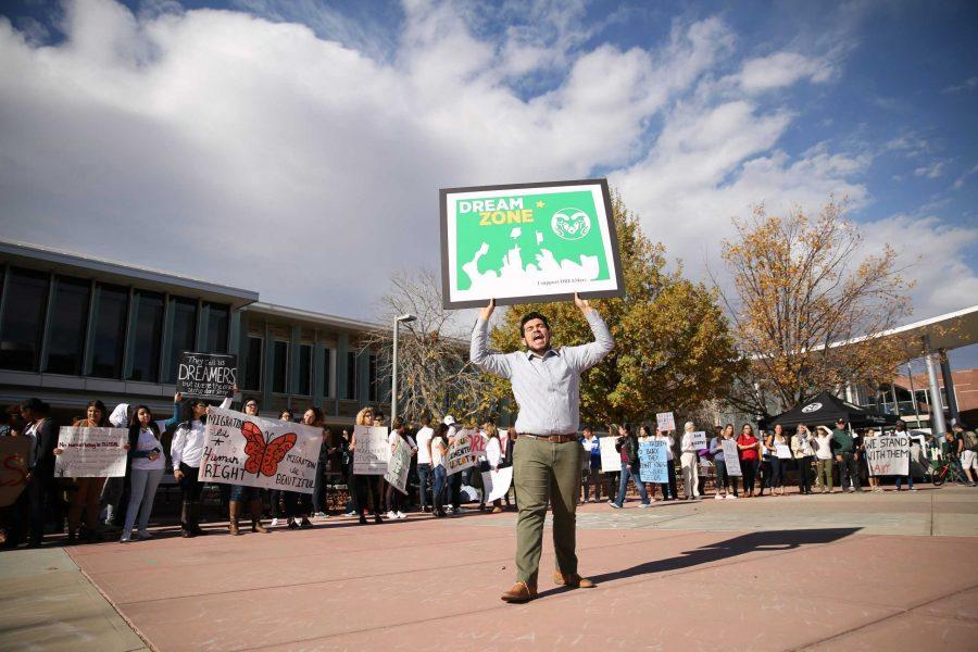 A supporter with DACA yells and holds a sign in support of DACA  and the rights of undocumented persons at Colorado State University during a rally in the Plaza on Monday. (Forrest Czarnecki | Collegian)