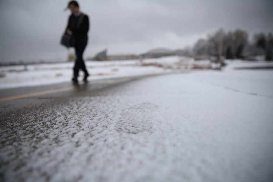 Footsteps are seen in the snow on sidewalk by the Lagoon on Thursday afternoon. Several inches of snow fell on Thursday afternoon, and temperatures are predicted to stay in the low 40s for Friday. (Forrest Czarnecki | Collegian)