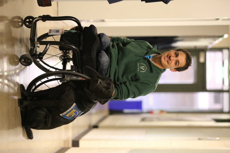 Bernard Dime poses for a portrait with his service dog, Corky, in the Anatomy building. Dime is the first paraplegic student in Colorado State University's veterinarian program. (Forrest Czarnecki | Collegian)