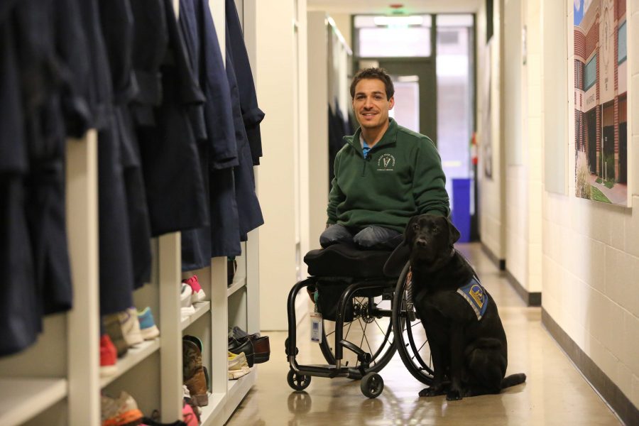Bernard Dime poses for a portrait with his service dog, Corky, in the Anatomy building. Dime is the first paraplegic student in Colorado State University's veterinarian program. (Forrest Czarnecki | Collegian)