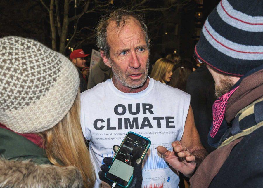 A protestor discusses climate change with reporters during Milo Yiannopoulos' event hosted at CU (Davis Bonner | Collegian)