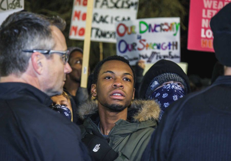 A protester to Milo Yiannopoulos' event at CU stands at the front amidst police crowd control (Davis Bonner | Collegian)