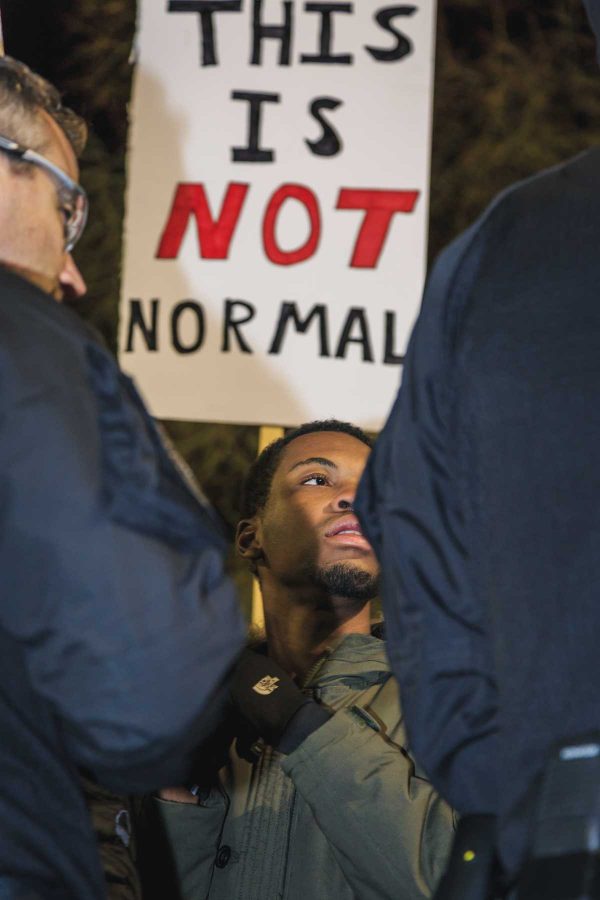 A protester to Milo Yiannopoulos' event at CU stands at the front amidst police crowd control (Davis Bonner | Collegian)