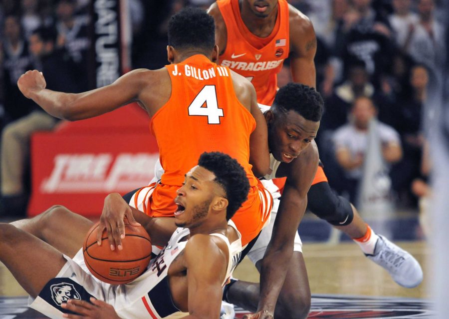 Connecticut Huskies guard Jalen Adams (2) grabs a loose ball as Connecticut Huskies center Amida Brimah (35) collides with Syracuse Orange guard John Gillon III (4) in the Tire Pros Classic on Monday, Dec. 5, 2016 at Madison Square Garden in New York City, N.Y. (Brad Horrigan/Hartford Courant/TNS)