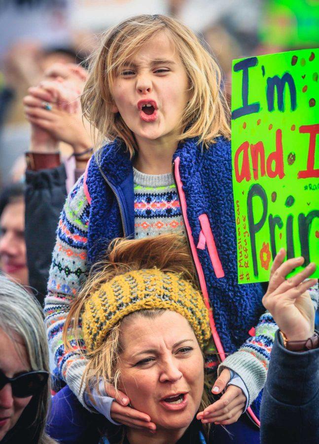 A young protester sits on her mother's shoulders to see above the estimated 10,000 person crowd during Denver's Muslim and immigrant solidarity event, February 4, 2017 (Davis Bonner | Collegian)