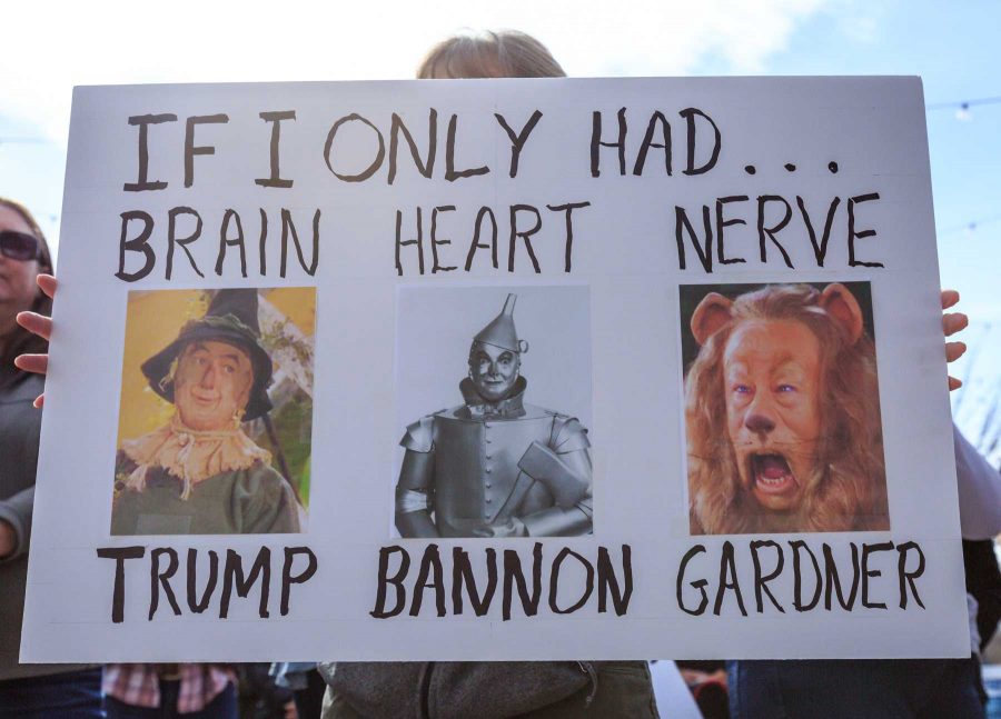 Kathy K. shows off her sign denouncing Trump, Bannon and Gardner during Fort Collins for Progress' rally in Old Town (Davis Bonner | Collegian)