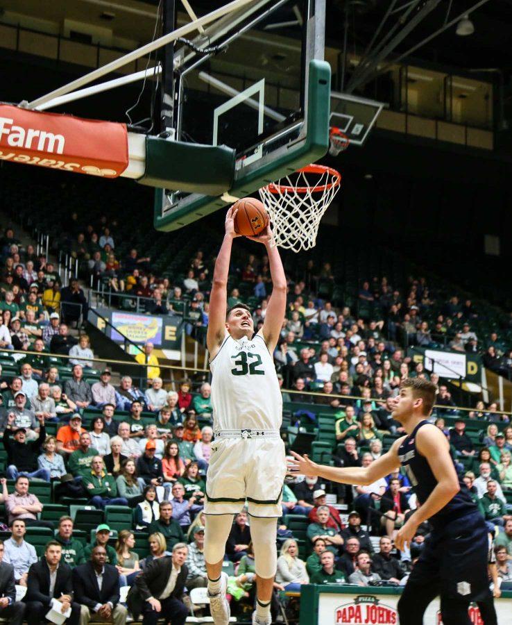Nico Carvacho dunks against Utah State defender Quinn Taylor helping the team to a 69-52 win. February 7, 2017 (Davis Bonner | Collegian)
