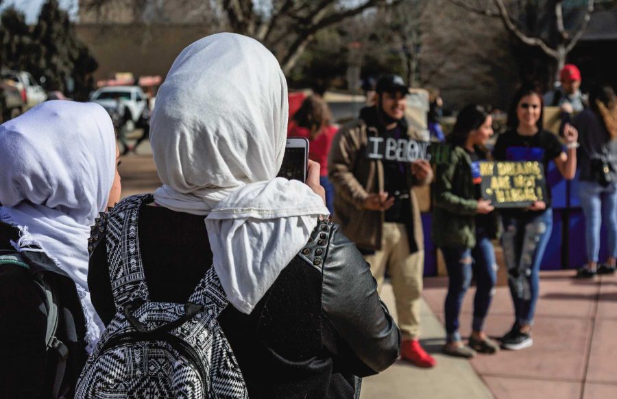 Two Muslim students watch as others take pictures with College Republicans at CSU's 'Free Speech Wall' during the "To Immigrants With Love" event on the plaza hosted by Dreamers United. February 8, 2017 (Davis Bonner | Collegian)